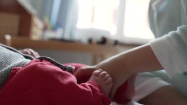 Büyük kardeş sevgi dolu beşikler bebek ayakları, yüzleri birbirine yakın, samimi ve samimi bir an yaratıyor, sıcak bir aile evinde.