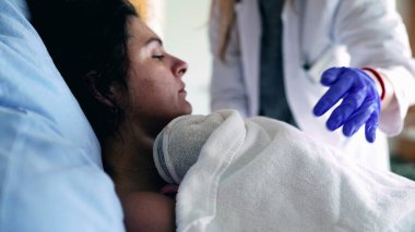 Mother Trembling with Pain After Giving Birth, Surrounded by Caring Medical Team in Maternity Clinic, as Newborn is Gently Placed on Her Chest clipart