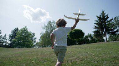Parkta Köpük Planörü Yetiştiren Küçük Çocuk Güneşli Bir Gün 'de Uçuşun Eğlencesini Yakalıyor
