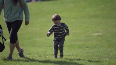 Güler yüzlü çocuk annesiyle Wooded Park 'ta yarışıyor.