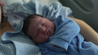 Huzurlu yeni doğmuş bebek, ilk gün annesinin kolunda dinleniyor. Huzurlu bebek mahrem günleri doğumdan sonra klinikte.