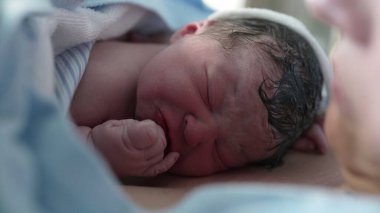 Yeni doğmuş bir bebeğin dünyaya gelişinin ilk dakikaları, ilk ağlamalar ve annesinin göğsünde dinlenen bebek gelişinin ilk anları anne bakımını vurguluyor.