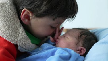 Ağabey ve yeni doğan bebek arasındaki hassas etkileşim, yakın aile ortamında kardeş bağının ve nazik bakımın altını çizmek. Yakalanmış aşk ve sıcaklık anları