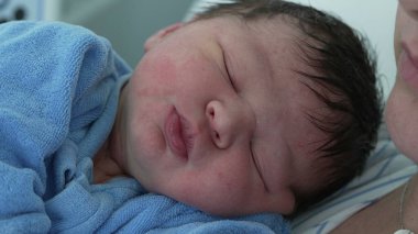 Yeni doğmuş bebek, hayatının ilk günü yakın plan yüzü. Gözleri kapalı bir bebek doğumdan sonra hastanede hayatının ilk saatleri