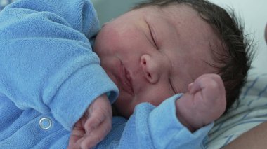 Yeni doğmuş bebek, hayatının ilk günü yakın plan yüzü. Gözleri kapalı bir bebek doğumdan sonra hastanede hayatının ilk saatleri
