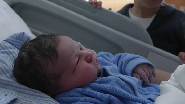 stock image Newborn baby infant being watched by brother at hospital clinic after childbirth, family moment welcoming new member of family