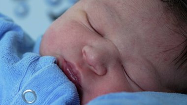 Hastanede yeni doğmuş bir bebeğin huzur içinde uyuması sakin ve besleyici bir ortamda yeni bir hayatın masumiyetini ve huzurunu vurguluyor.