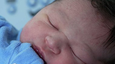 Hastanede yeni doğmuş bir bebeğin huzur içinde uyuması sakin ve besleyici bir ortamda yeni bir hayatın masumiyetini ve huzurunu vurguluyor.