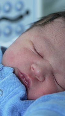 Hastanede yeni doğmuş bir bebeğin huzur içinde uyuması, sakin ve besleyici bir ortamda yeni bir hayatın masumiyetini ve huzurunu ön plana çıkarıyor.