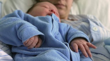 Mavi Tulumlu Huzurlu Yeni Doğan Ebeveynlerin Kollarında Yuvalanmış Samimi Erken Bağ Anları