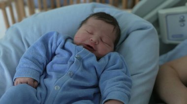 Newborn baby sleeping peacefully in a cozy outfit, resting on a cushion, representing tranquility and innocence, healthcare setting, postnatal care, early life, family love, and nurturing