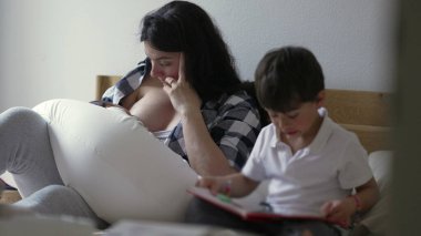 Annesi yeni doğmuş bebeği emzirirken büyük oğlu yanında bir kitap okuyor. Anne, ekose gömlekli, bebeğini büyütüyor, aile hayatının sakin bir anını yakalıyor ve yatakta kardeş ilişkileri kuruyor.