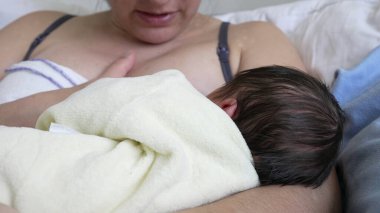 Yeni doğan bebek hastane yatağında annesiyle emziriyor, anne ile çocuk arasındaki yakınlık ve beslenme anını yakalıyor, aile, sağlık ve ebeveynlik için ideal.