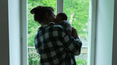 Anne sevgiyle yeni doğmuş bebeğini kucağına alıyor, bu samimi aile anındaki yakınlık ve sevgiyi vurguluyor.