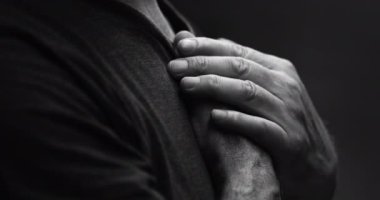 Son sınıf öğrencisi, elleri göğsünde sessizce yansıyan, Tanrı 'nın lütfuna minnettar hisseden, dramatik siyah beyaz.