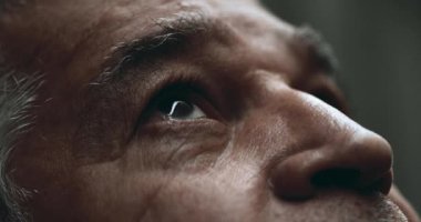 Yaşlı bir adam gökyüzüne tepeden bakan yakın çekim gözleri. 70 'li yaşlarda buruşuk bir ifadeyle derin düşüncelere dalmış.