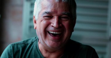 Mutlu yaşlı bir adam kameraya bakarken çılgınca gülüyor. Gri saçlı, yakından bakan, gamsız 70 'li yaşlarda biri.