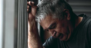 Üzgün, bunalımlı yaşlı adam umutsuzluk içinde ağlıyor metal çubuğu kavrayıp derin melankoli ve pişmanlıkla gözyaşı dökerek aşağıya bakıyor. Kederli yaşlı kişi
