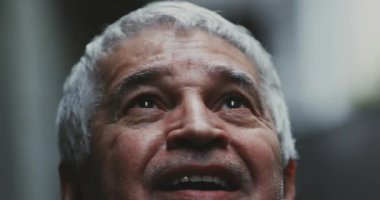 Mutlu, sadık, kıdemli bir adam gökyüzüne bakıp gülümsüyor. Tanrısallığın varlığını huşu içinde hissederek yukarı bakıyor. Tıraşsız yaşlı bir insan. Yüzü ve gözleri yakın çekim.