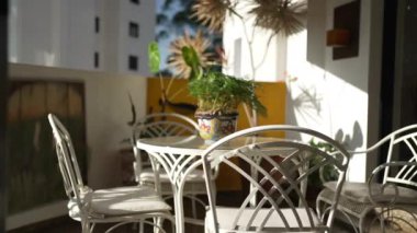 Beyaz sandalyeli ve masalı modern bir oturma odasının iç tasarımı.