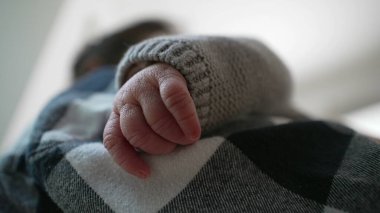 Anne ve çocuk arasındaki hassas ve samimi bağı vurgulayarak, yeni doğmuş bir bebeğin elinin annesinin omzunda dinlenmesi. 