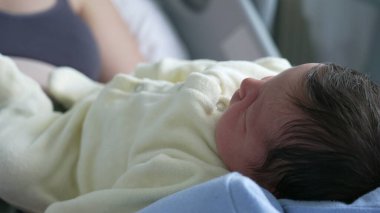 Yeni doğan bir bebeğin huzur içinde dinlenmesi, Yumuşak Özellikler ve Kapalı Kapalı Hastane Ortamı 'ndaki Koyu Saçlar