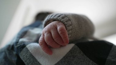 Anne ve çocuk arasındaki hassas ve samimi bağı vurgulayarak, yeni doğmuş bir bebeğin elinin annesinin omzunda dinlenmesi. 