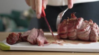 Bir bıçak ve çatalla taze ızgara et dilimleme, sulu ve yumuşak dokuyu yakalama, ızgara pişirmenin leziz sonuçları, mutfak sürecine yakından bakma,