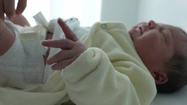 Hemşire hastane rutini sırasında altını değiştirirken yeni doğan bebekler ellerini uzatıyor. Yeni doğan bebekler için hassas bakım ve bakım gereksinimleri, ilk günlerde nazik bakımın önemini vurgulamak 