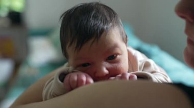 Anne yeni doğmuş bebeği kucağında tutuyor, ikisi de sakin ve huzurlu görünüyor. Yumuşak bir kucaklama ve sıcak bir yuva kurmak anne ve çocuk arasındaki sevgi bağını vurgular, barışçıl bir atmosfer yaratır.