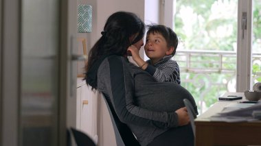 Anne ve çocuğun mutlulukla kucaklaşması, ev ortamları, sıcak ve sevgi dolu etkileşimler, doğal ışık, aile bağı, mutlu an, huzurlu ev ortamı, annelik bağı, beslenme ilişkisi