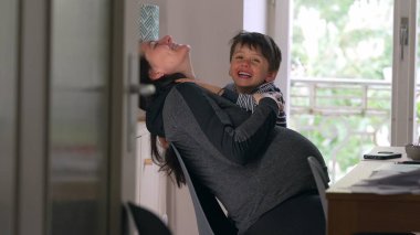 Anne ve çocuk birlikte gülüyor, ev ortamları, neşeli ve eğlenceli etkileşimler, doğal ışık, aile bağı, mutlu an, huzurlu ev ortamı, annelik bağı, besleyici ilişki