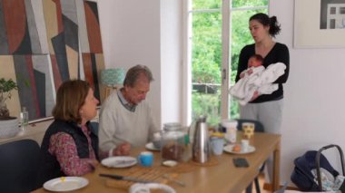 Anne yeni doğmuş bebeği sıcak bir evde tutuyor, hassas bir an, beyaz battaniyeye sarılmış bebek, aile bağı, bakım, huzurlu bir sahne, erken çocukluk, annelik aşkı