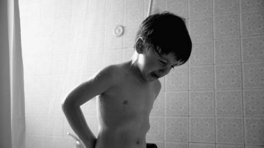 Duşun altında ağlayan küçük çocuk, banyo zamanı, duygusal an, ıslak saç ve ten, banyo sahnesi, çocuk hijyeni, gözyaşı ve su damlacıkları sırasında sıkıntılı çocuğun siyah beyaz fotoğrafı.