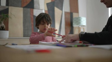 Ebeveynler çocuklarına bir kalemle ödev yoluyla rehberlik eder, ebeveynlerin eğitime katılımının rolünü vurgular ve öğrenim için destekleyici ev ortamını vurgularlar