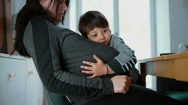 Stock image Pregnant woman with her young child hugging her belly, showcasing a candid and heartfelt moment of affection and bond between mother and son