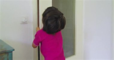 Çocuk bir evin koridorunda koşuyor, neşeli bir enerji ve hareket anı yakalıyor, çocukluğun kaygısız ruhunu ve neşesini aile ortamında gösteriyor.