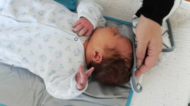 Anne, banyo yaptıktan sonra bebeğin saçlarını yumuşak bir havluyla kurular.