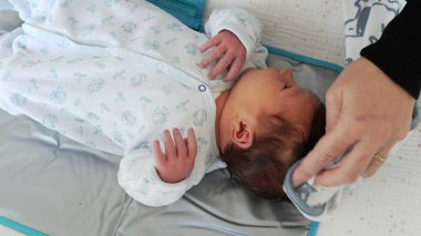 Anne, banyo yaptıktan sonra bebeğin saçlarını yumuşak bir havluyla kurular.