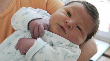 Yeni doğan bebeğin ilk günlerinde kucağına alındığı yakın plan. bebek gözlemleme dünyası