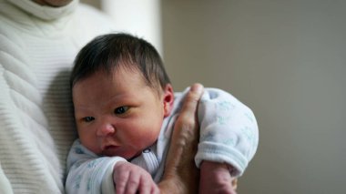 Yaşamın ilk haftası boyunca yeni doğan bebeğin yakın çekimi, bebeğin ilk evreleri, büyükannesi tarafından tutuluyor.