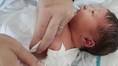 Yeni Doğan Bebek - Anne Bebek Elleri, Yakın plan. Bir annenin, yeni doğmuş oğlunun minik ellerini giydirip, anne ile çocuk arasındaki bağın altını çizdiği hassas bir an.