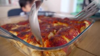 Taze pişmiş, yemek masasındaki cam bir tencerenin içinde ev yapımı enchiladalar servis edilmeye ve keyif almaya hazır.