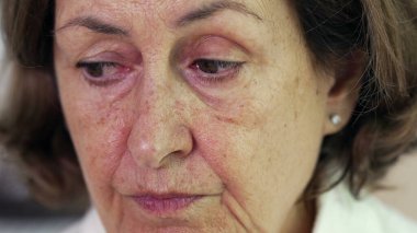 Düşünceli, yorgun, son sınıf öğrencisi, endişeli bir yüz ifadesi olan, derin zihinsel yansıması olan, 70 'li yaşlarda buruşuk, yaşlı bir kadın.