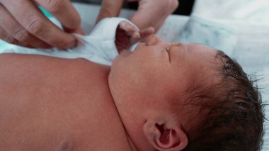 Yeni Doğan Bebek - Anne Bebek Elleri, Yakın plan. Bir annenin, yeni doğmuş oğlunun minik ellerini giydirip, anne ile çocuk arasındaki bağın altını çizdiği hassas bir an.