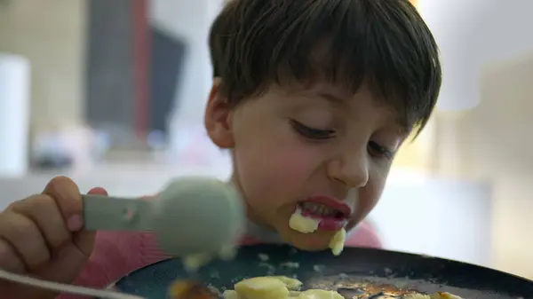 stock image Little boy eating food during mealtime, close-up face of 5 year old child eating smashed potatoes with spoon, rolling eyes and acting silly while dinner time