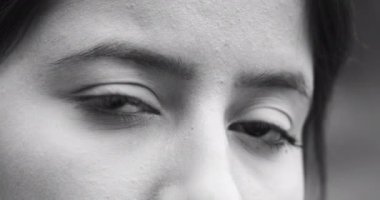 Siyah beyaz gözler kameraya bakıyor. Kız izleyiciyi fark eder.