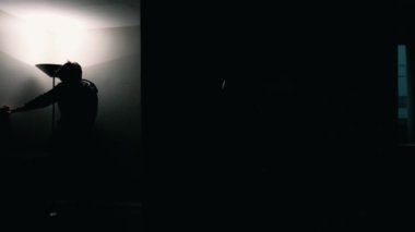 Genç adam evdeki lambaları yakıyor. 