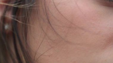 Genç bir kadının boynuna ve saçına yakından bakın.