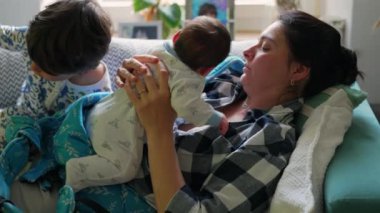 Anne kanepede oturuyor, bebeğini kucağında tutuyor ve onunla nişanlanıyor. Rahat bir ev ortamında anne ve çocuk arasındaki yakın bağ
